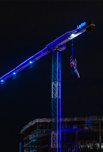 Nighttime view of one of Layton's construction cranes lit with blue lights