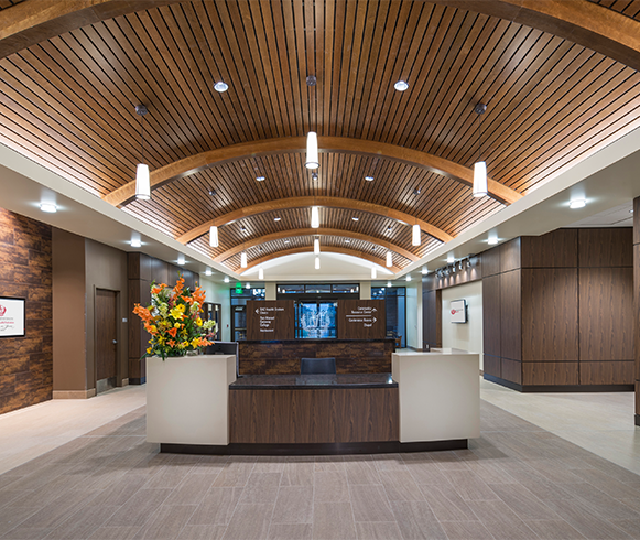 The reception area at SACHS Norton Clinic with tile floors and a wood feature ceiling.