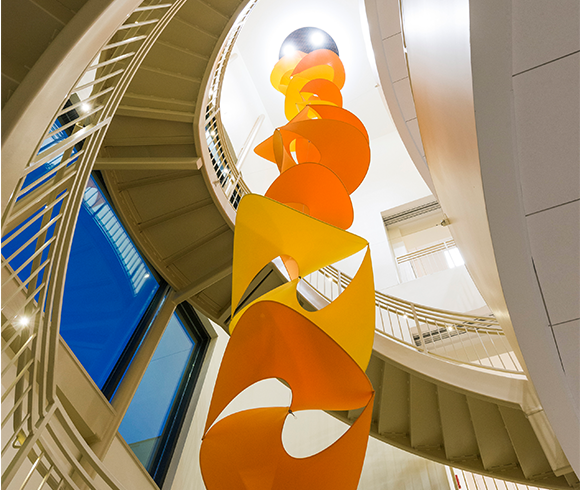 An orange sculpture feature that hangs between the staircase.