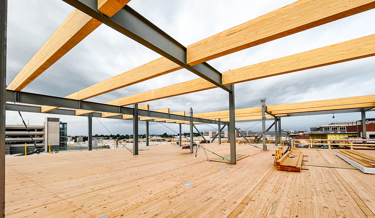 View of wooden and steel support beams at a Mass Timber construction site