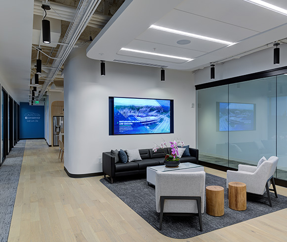 A sitting area at the front of the office with a couch and two chairs.