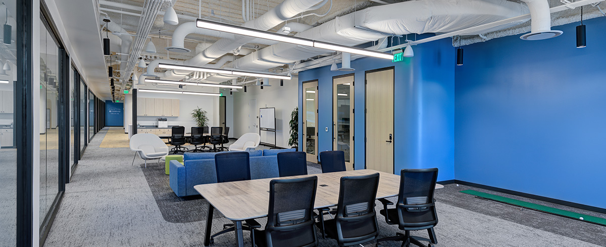 An open office area with a meeting table, couch and chairs for employees to have open collaboration.