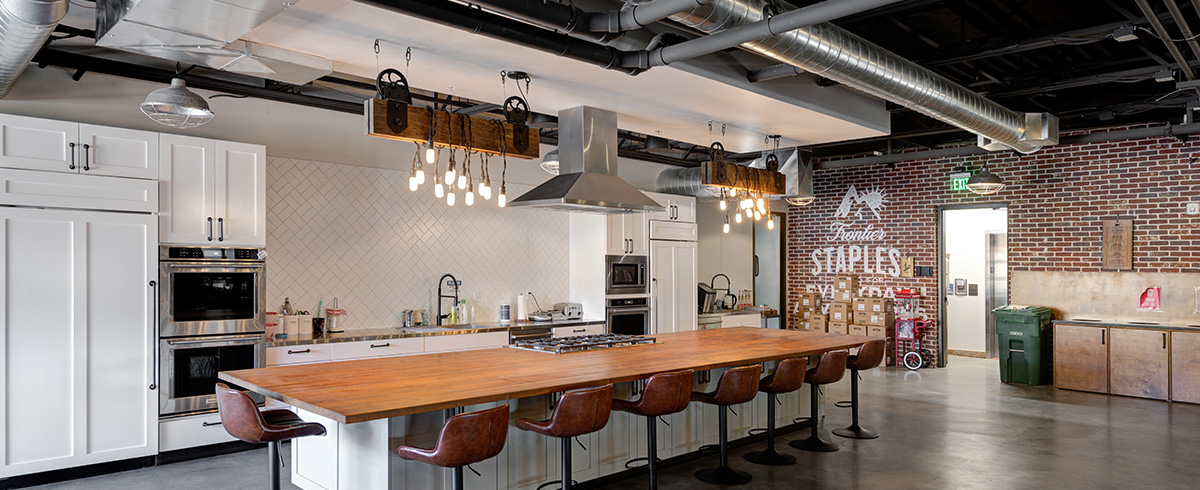 High-end kitchen space with white tile backsplash at Kodiak Cakes office.
