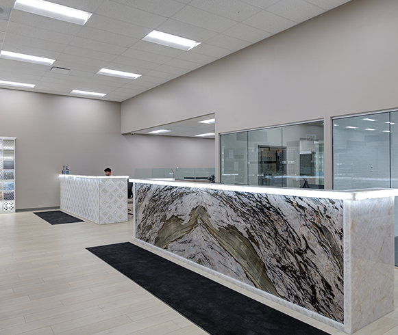 A reception area with two large reception desks made out of tile.