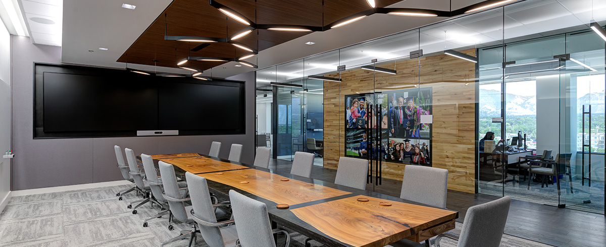 A large conference room with a TV screen and several chairs.
