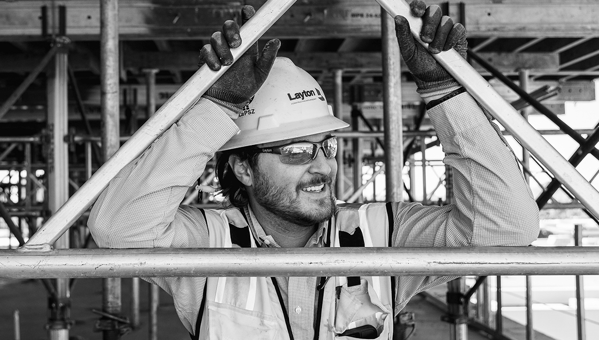 A black and white photo of a Layton employee on a project site wearing full PPE.