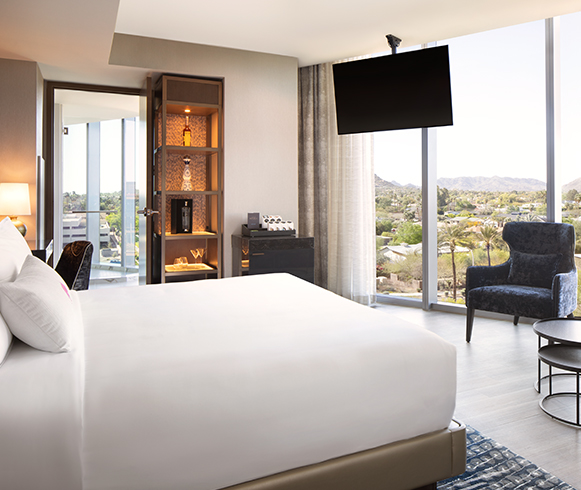 Interior photo of Caesars Republic hotel showing a guest bedroom with bed and floor-to-ceiling windows.