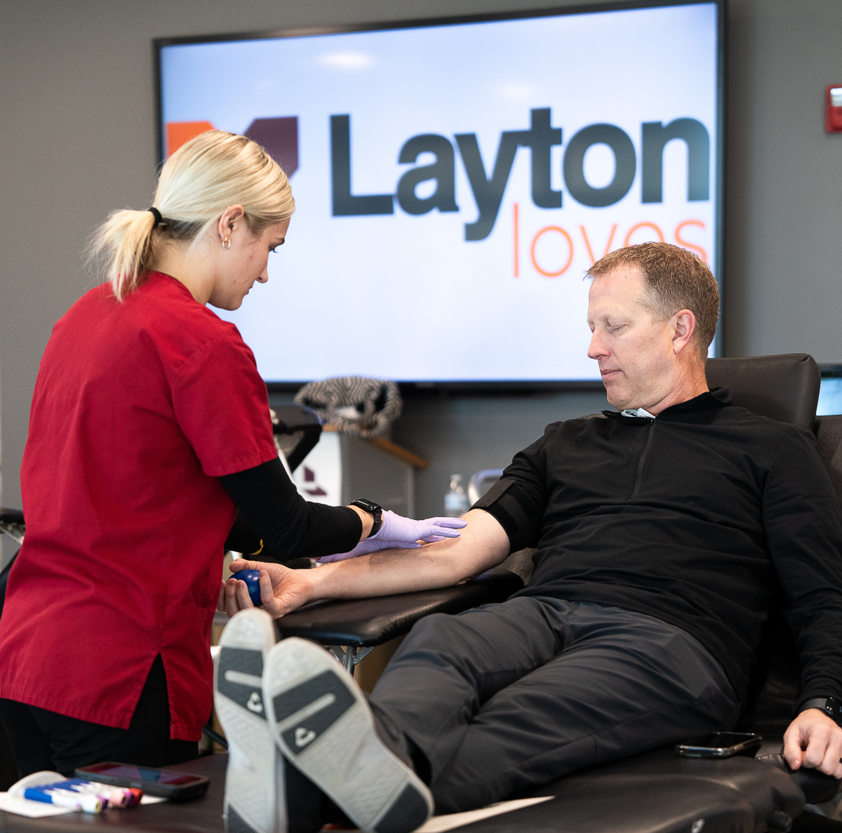 An employee participating in a Layton Loves blood drive with the American Red Cross