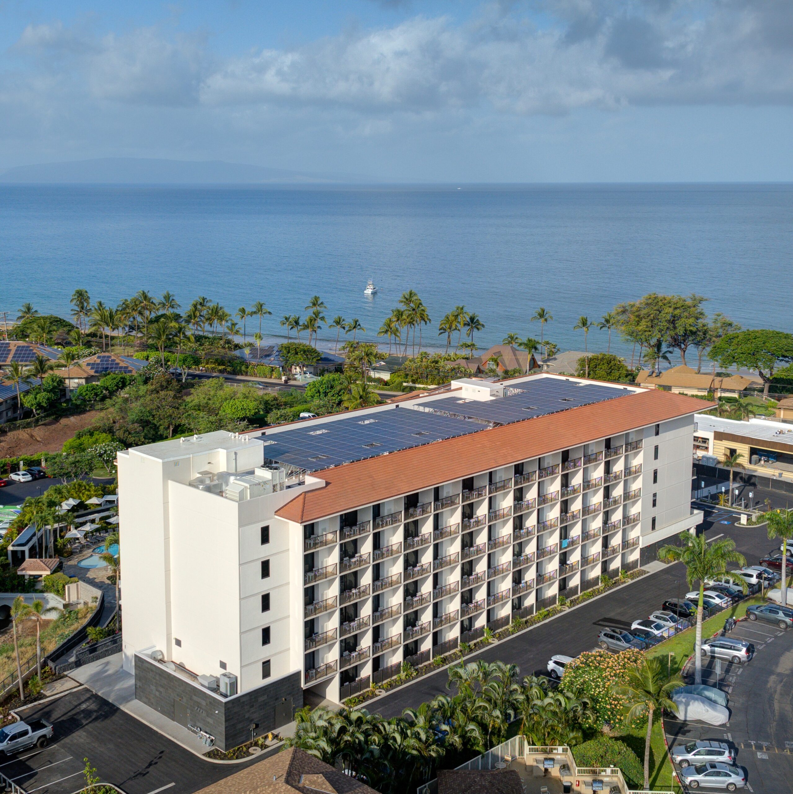 Exterior of island hotel with ocean and palm trees