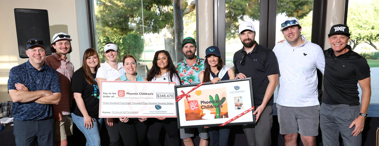 Layton presents a check to Phoenix Children's Hospital after raising money at their annual golf tournament.