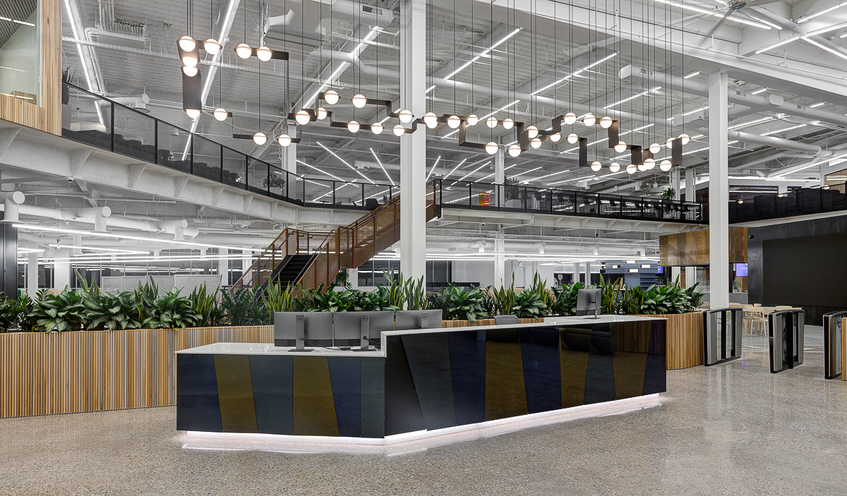A large reception area with modern light fixtures hanging from the ceiling.