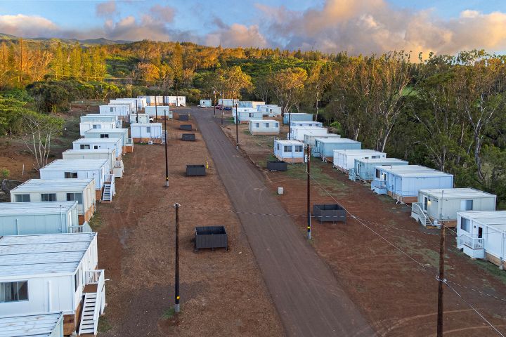 Aerial view of Kapalua Village Emergency Housing community in Maui, with rows of white modular homes built for families displaced by the 2023 Lahaina wildfires.
