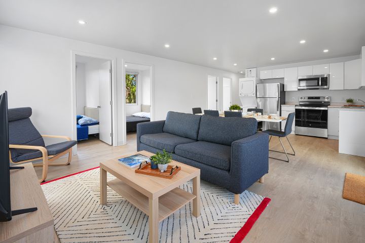 Modern interior of an emergency housing unit in Kapalua Village, featuring a cozy living room, fully equipped kitchen, and two bedrooms.